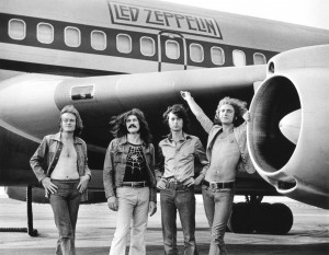 (L-R) John Paul Jones, John Bonham, Jimmy Page and Robert Plant of Led Zeppelin in front of plane in NY. July 24, 1973. © Bob Gruen 