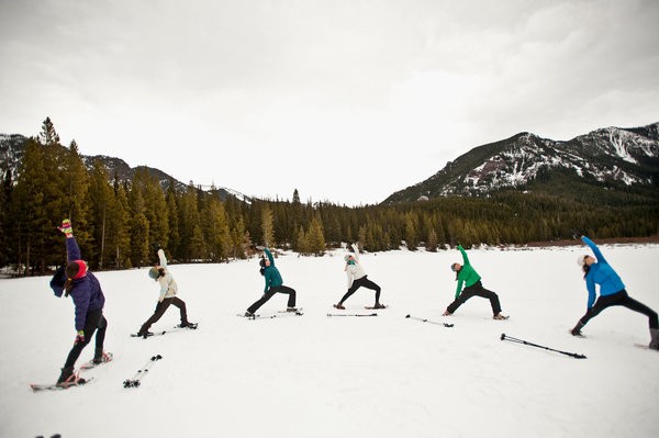 In Bozeman, Mont., participants in a twice-weekly class snowshoe to their destination as a warm-up, do about a half-hour of yoga, including the reverse warrior pose, and then snowshoe home. Credit Lynn Donaldson for The New York Times 