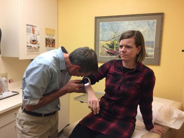 Dr. Kent Gaylord examines Amy Tokarz with a new skin cancer screening tool. Courtesy photo.